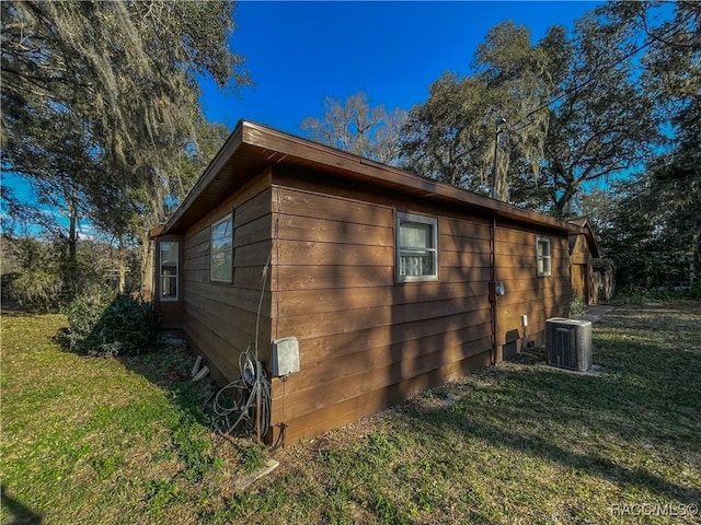 view of home's exterior featuring cooling unit and a yard