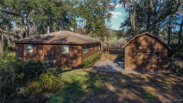 view of side of home featuring a garage, an outdoor structure, and a lawn