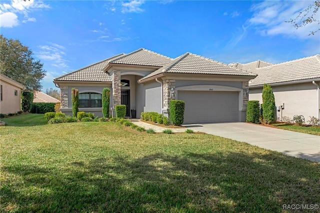 mediterranean / spanish house with an attached garage, a tile roof, a front lawn, and concrete driveway