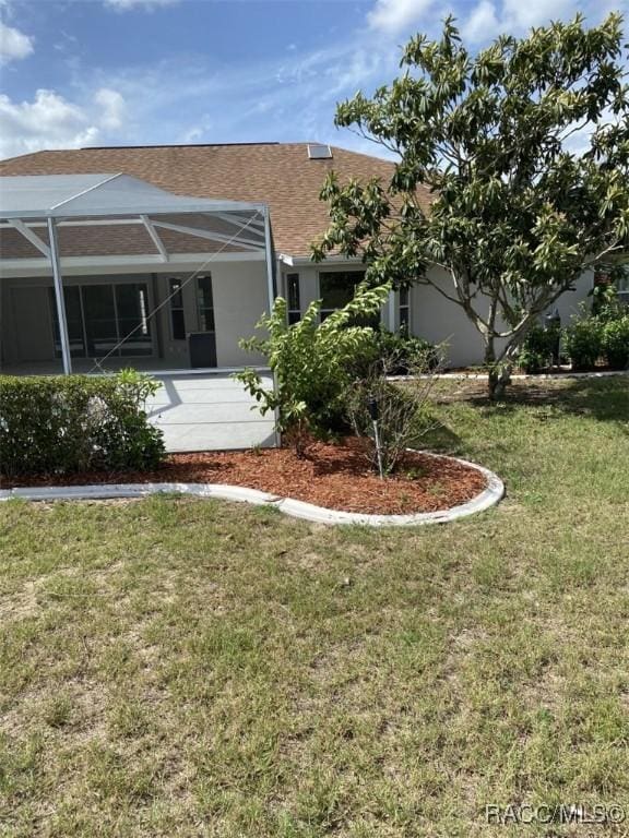259 N Cherry Pop Dr, Inverness, FL 34453 - back of property with a lawn, glass enclosure, stucco siding, and roof with shingles