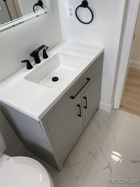 259 N Cherry Pop Dr, Inverness, FL 34453 - bathroom with vanity, marble finish floors, toilet, and baseboards