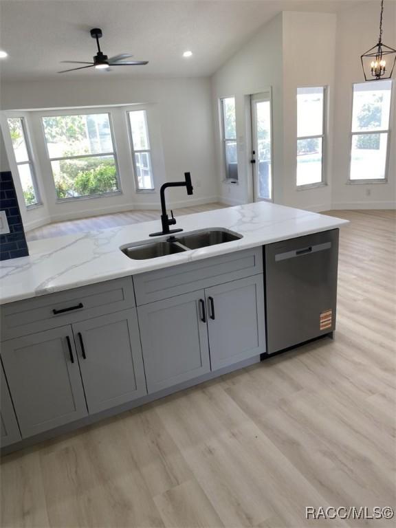 259 N Cherry Pop Dr, Inverness, FL 34453 - kitchen with stainless steel dishwasher, a sink, light wood-type flooring, light stone counters, and recessed lighting