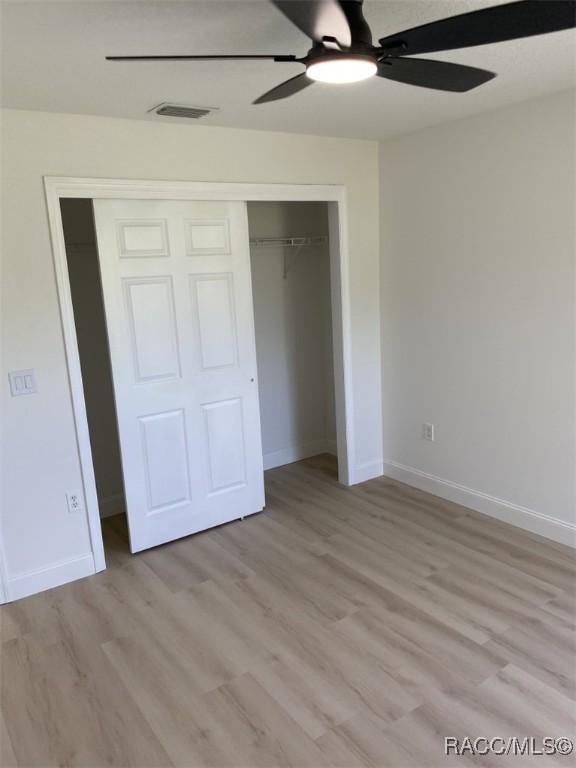 259 N Cherry Pop Dr, Inverness, FL 34453 - unfurnished bedroom with a closet, baseboards, and light wood-style floors