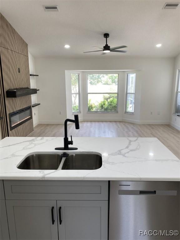 259 N Cherry Pop Dr, Inverness, FL 34453 - kitchen with a sink, dishwasher, gray cabinetry, light wood-style flooring, and recessed lighting