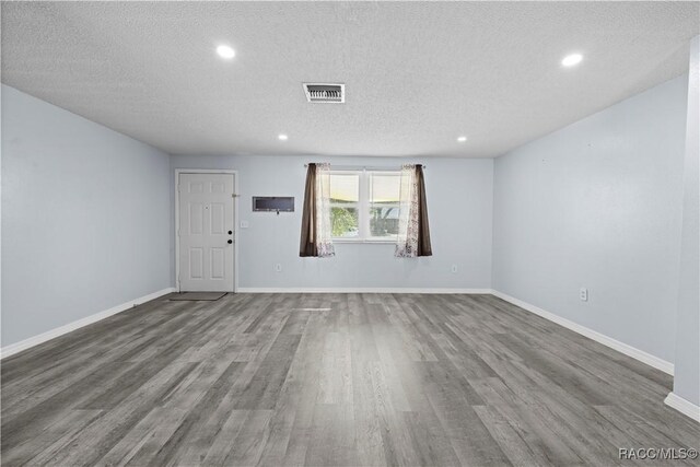 unfurnished room featuring a textured ceiling and hardwood / wood-style flooring