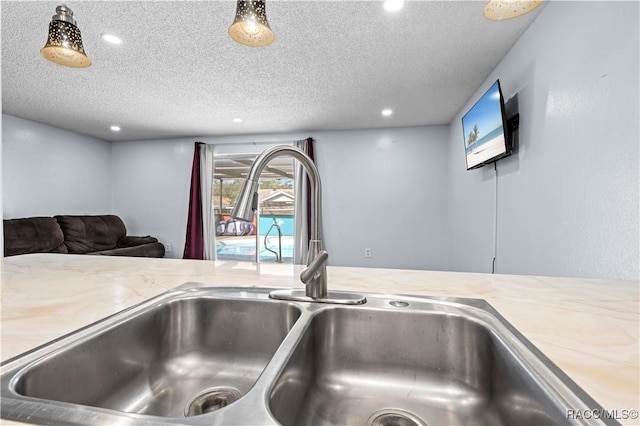 interior details featuring light stone countertops, a jacuzzi, sink, and a textured ceiling