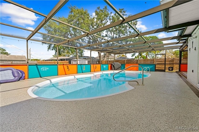 view of pool with glass enclosure and a patio