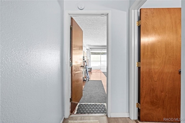 hall with a textured ceiling