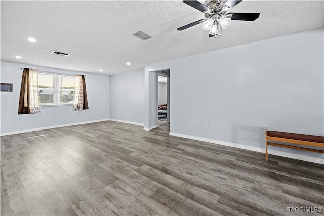 spare room with a textured ceiling, ceiling fan, and dark hardwood / wood-style floors