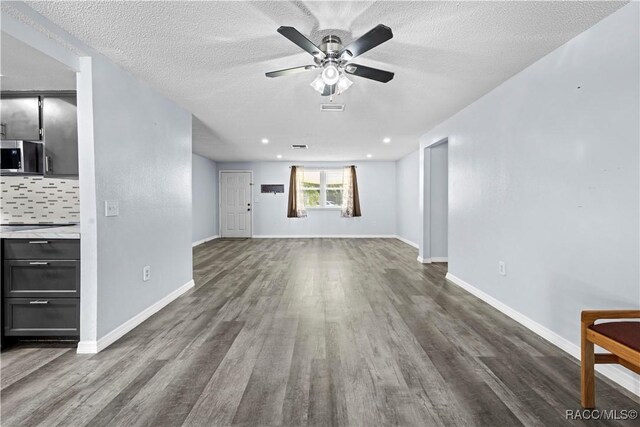 unfurnished living room featuring a textured ceiling, dark wood-type flooring, and ceiling fan