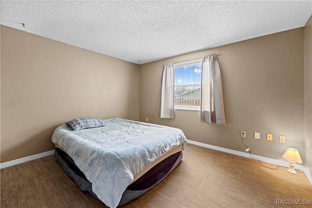 bedroom featuring a textured ceiling and hardwood / wood-style floors