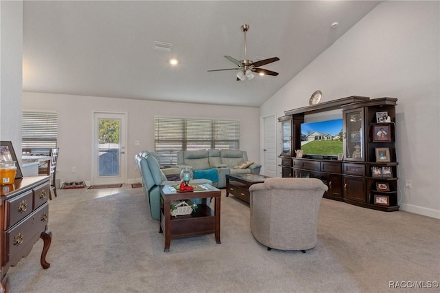 living area with high vaulted ceiling, light colored carpet, ceiling fan, and baseboards