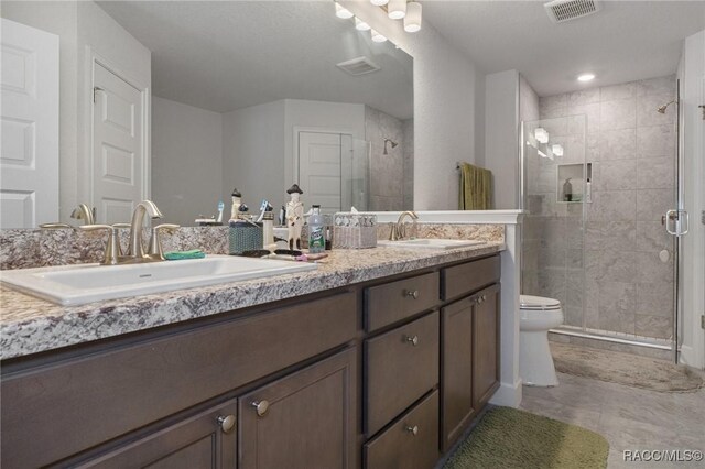 full bath with double vanity, visible vents, and a sink