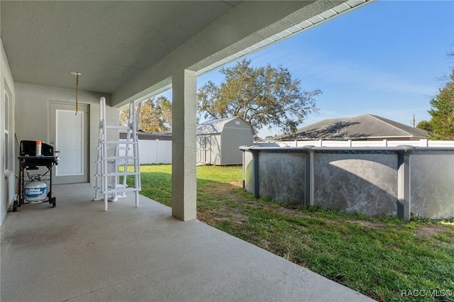 view of patio / terrace featuring a grill, fence, a shed, an outdoor pool, and an outdoor structure