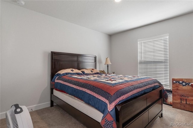 bedroom featuring baseboards and light colored carpet