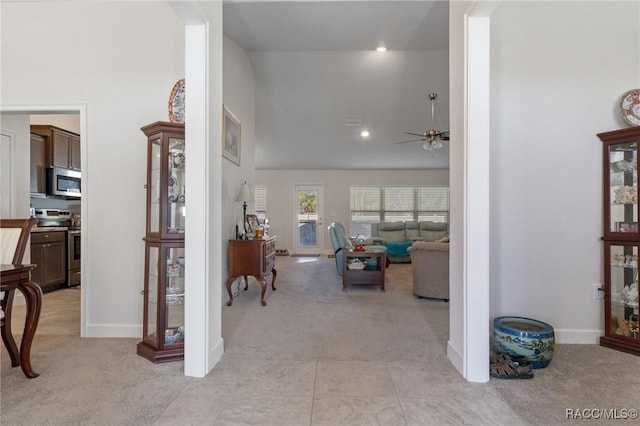 corridor featuring light carpet, baseboards, high vaulted ceiling, and recessed lighting