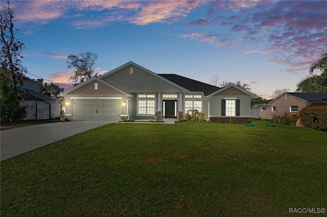 view of front of home featuring a garage, a front yard, driveway, and stucco siding