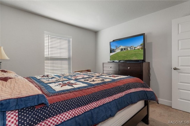 bedroom featuring light carpet and baseboards