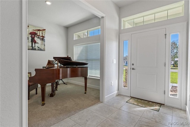 entryway featuring light carpet, baseboards, and light tile patterned flooring