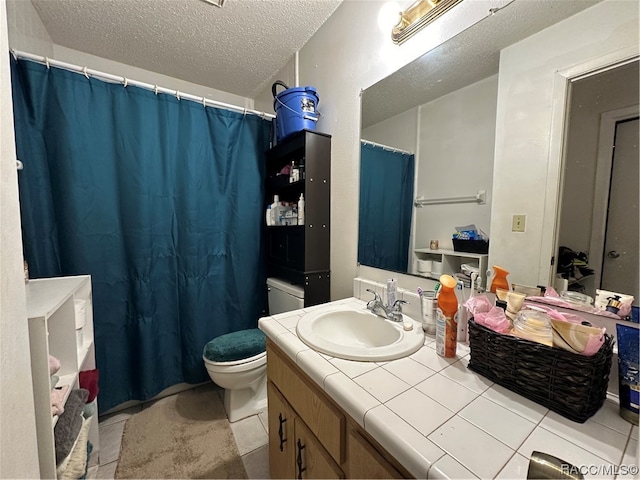 bathroom with vanity, a textured ceiling, toilet, and tile patterned flooring