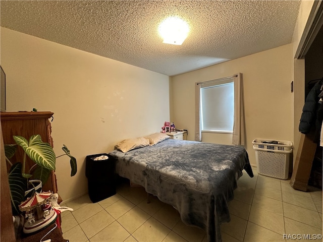 bedroom featuring a textured ceiling and light tile patterned flooring