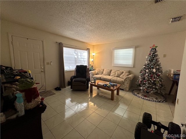 living room featuring a textured ceiling, a wealth of natural light, and light tile patterned flooring