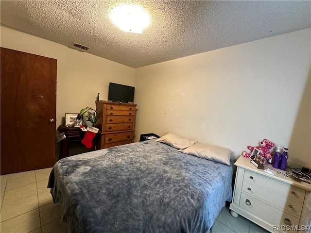 bedroom featuring light tile patterned floors and a textured ceiling