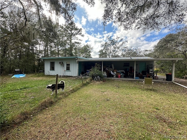 back of house with a carport and a yard