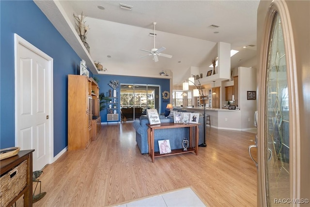 kitchen with kitchen peninsula, ceiling fan, lofted ceiling, and light wood-type flooring