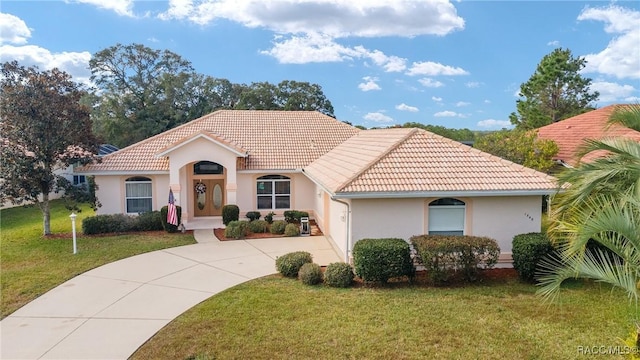 mediterranean / spanish home with a front lawn