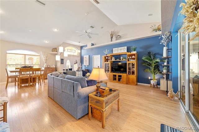 living room with ceiling fan, high vaulted ceiling, and light hardwood / wood-style floors