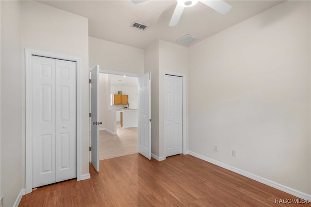 2459 N Brentwood Cir, Lecanto, FL 34461 - unfurnished bedroom with two closets, wood finished floors, and ceiling fan