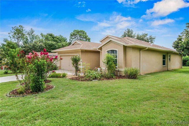2459 N Brentwood Cir, Lecanto, FL 34461 - view of home's exterior with stucco siding, a garage, driveway, and a lawn