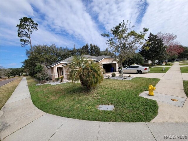 view of side of property with a lawn and driveway