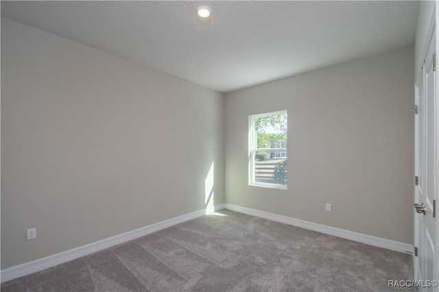 unfurnished room featuring light carpet