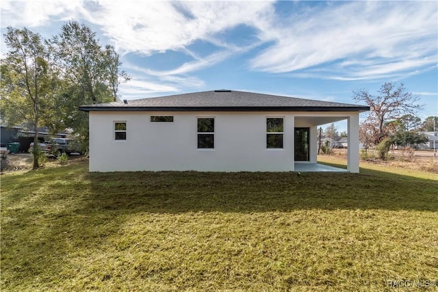 back of property with a yard and a patio area