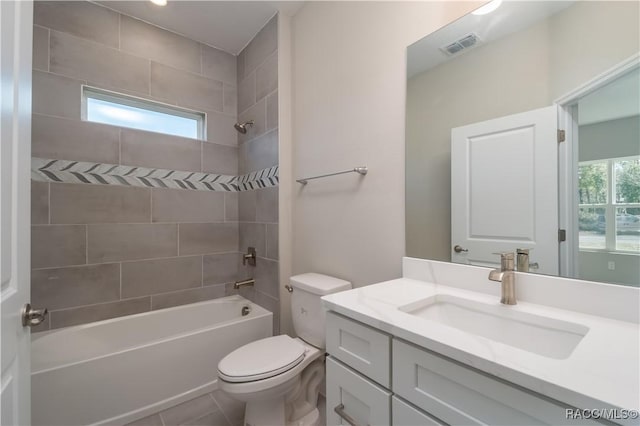 full bathroom featuring vanity, tile patterned floors, toilet, and tiled shower / bath