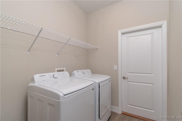 laundry area featuring washing machine and clothes dryer and light wood-type flooring