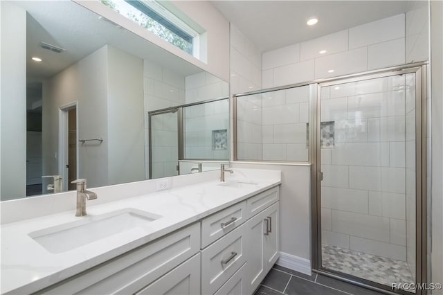 bathroom featuring a shower with door, vanity, and tile patterned floors