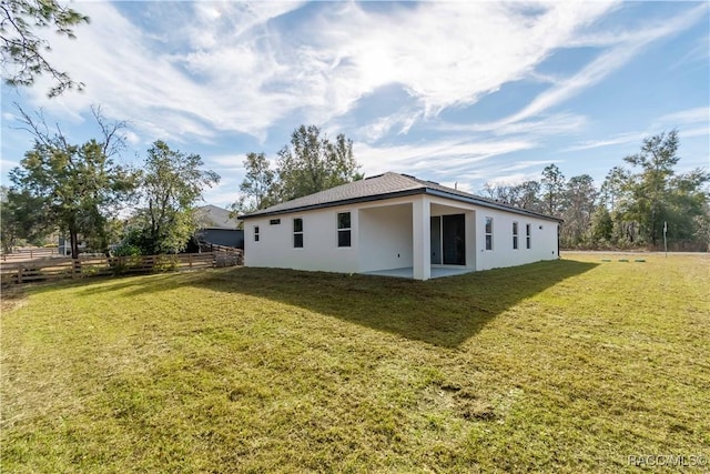 rear view of property with a yard and a patio