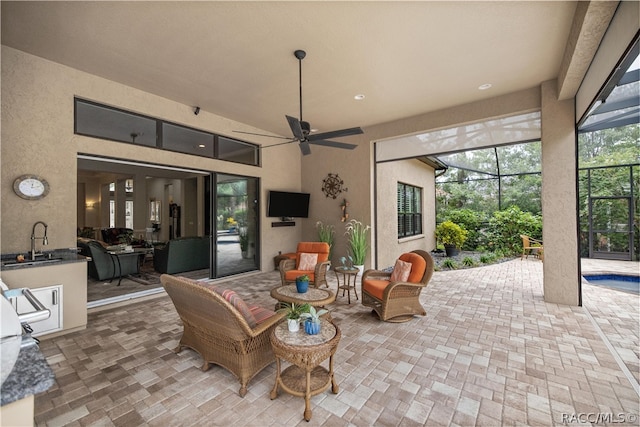 view of patio / terrace with a swimming pool, glass enclosure, ceiling fan, and sink