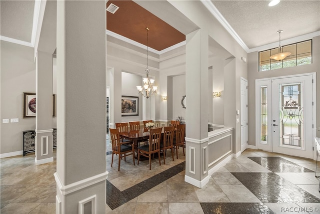 entrance foyer with a notable chandelier, ornamental molding, a textured ceiling, and a high ceiling