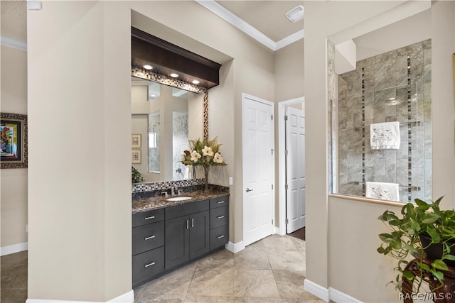 bathroom with vanity, a tile shower, and crown molding