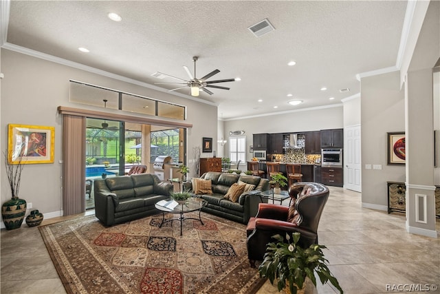 living room featuring a textured ceiling, ceiling fan, light tile patterned floors, and crown molding