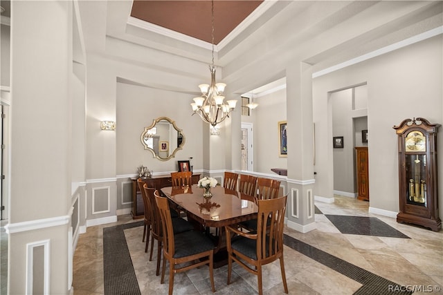 dining space featuring a tray ceiling, crown molding, and a notable chandelier