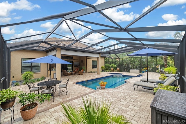 view of pool featuring glass enclosure, a patio area, and a hot tub