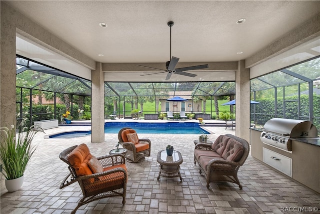 view of patio featuring outdoor lounge area, glass enclosure, grilling area, and exterior kitchen