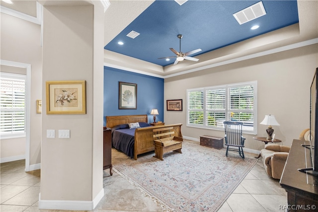 tiled bedroom with a raised ceiling, ceiling fan, and a textured ceiling