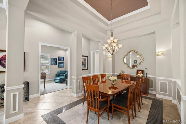 dining room with light tile patterned floors, crown molding, a tray ceiling, and an inviting chandelier