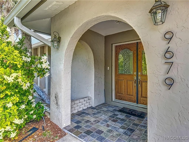 entrance to property featuring stucco siding